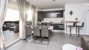 A modern living room with a dining area, a kitchen, and a balcony. - Villa Magnifica Penthouse with Jacuzzi (Novalja)