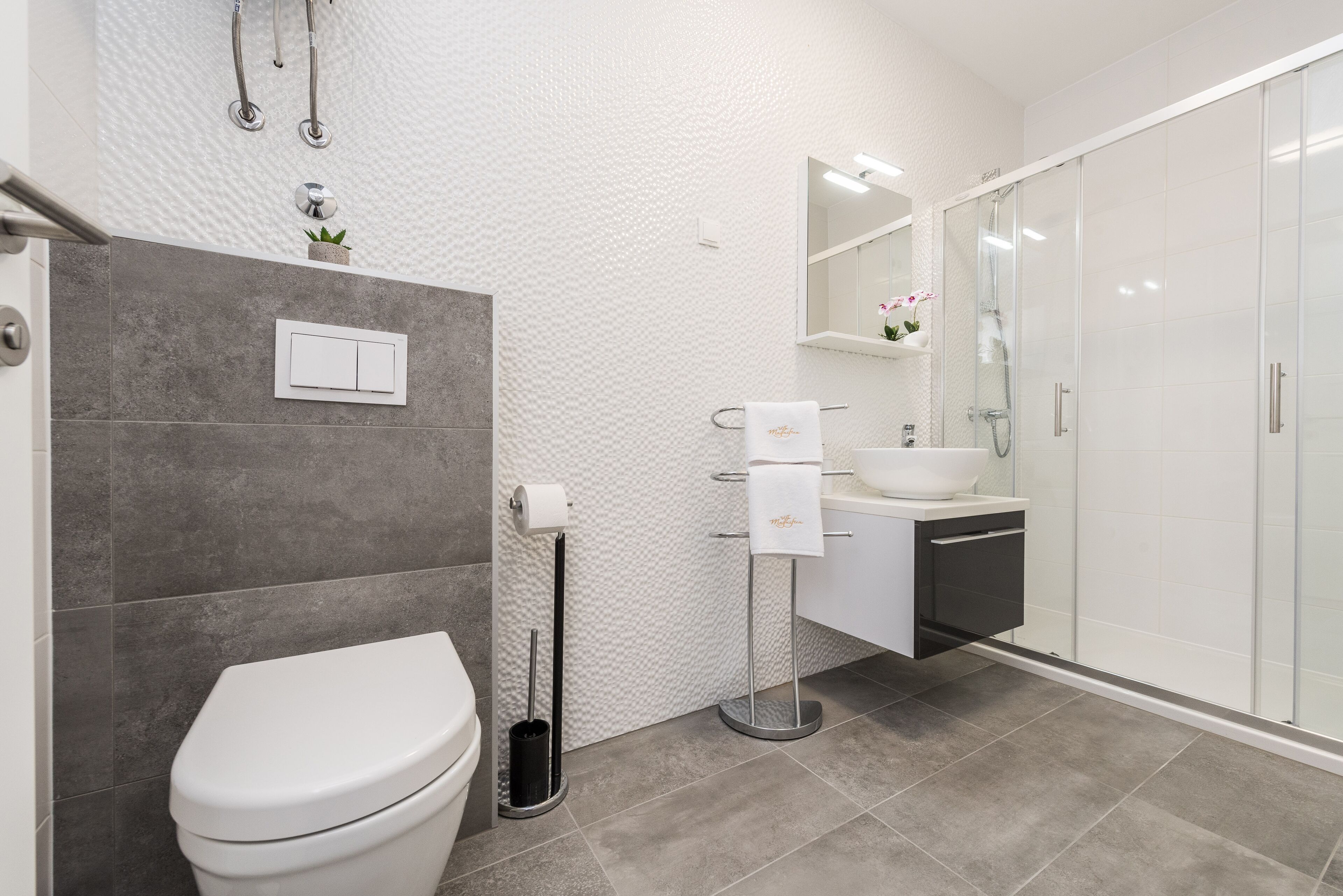A modern bathroom with a toilet, bidet, and shower.