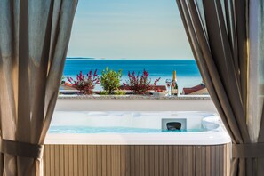 A hot tub with a view of the sea, a bottle, and some plants. - Villa Magnifica Penthouse with Jacuzzi (Novalja)