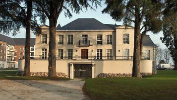 A large, multi-story building with a symmetrical facade, a central entrance, and a stone foundation.