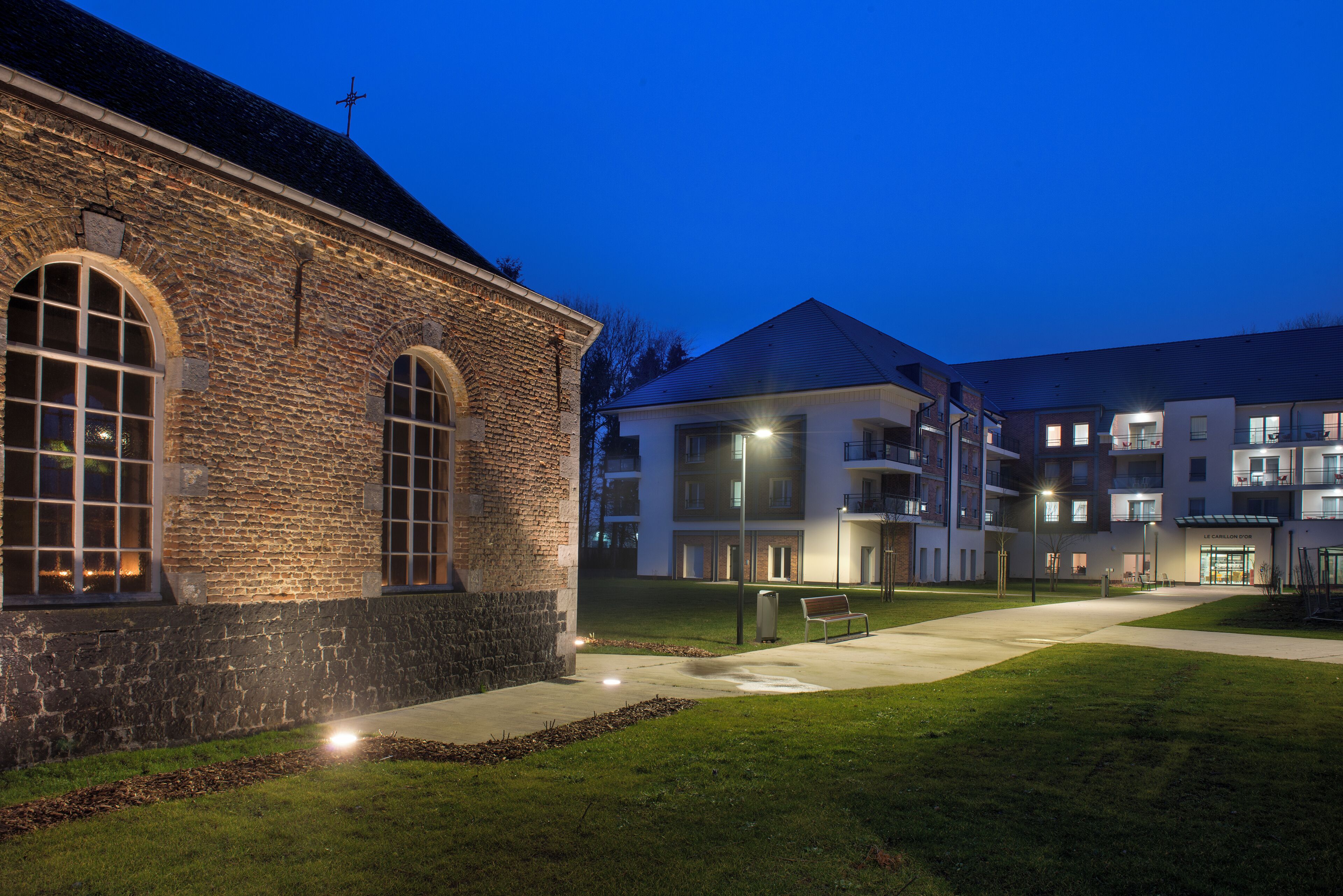 A building with a stone facade, large arched windows, and a flat roof.