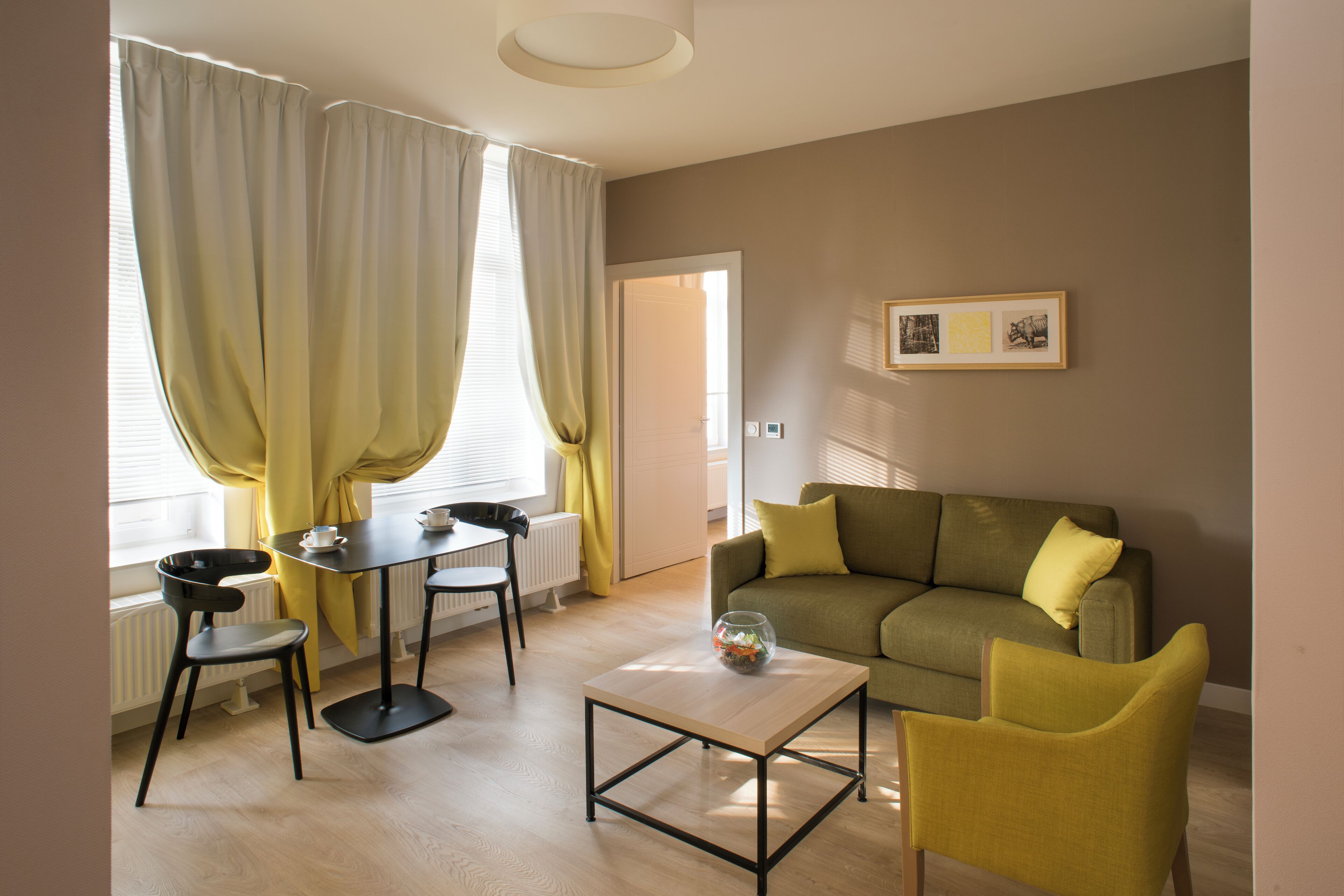 Un salon moderne comprenant un canapé, une table basse et un coin repas avec une table et des chaises.