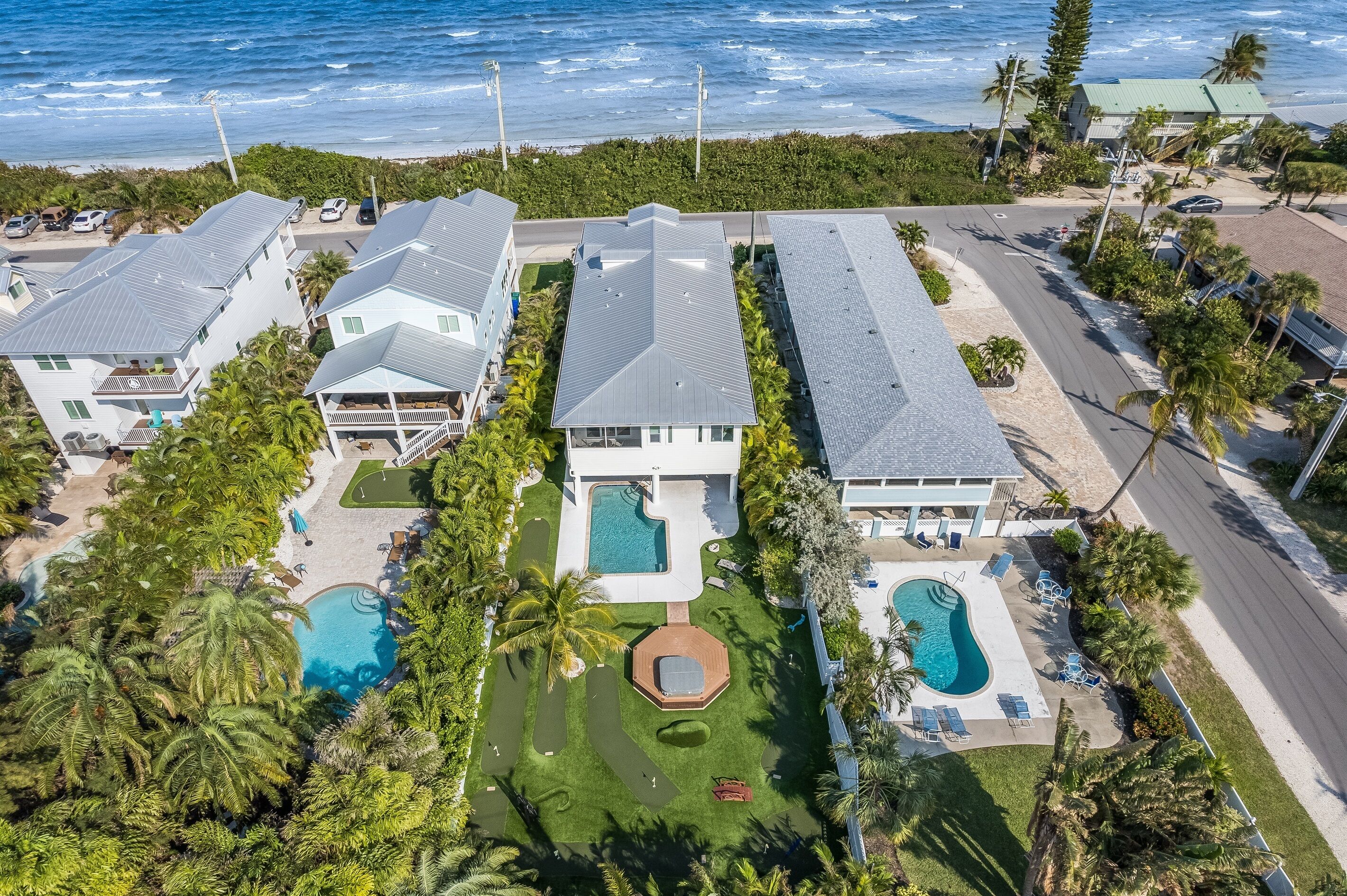 A coastal property with multiple buildings, a swimming pool, and a well-maintained lawn.
