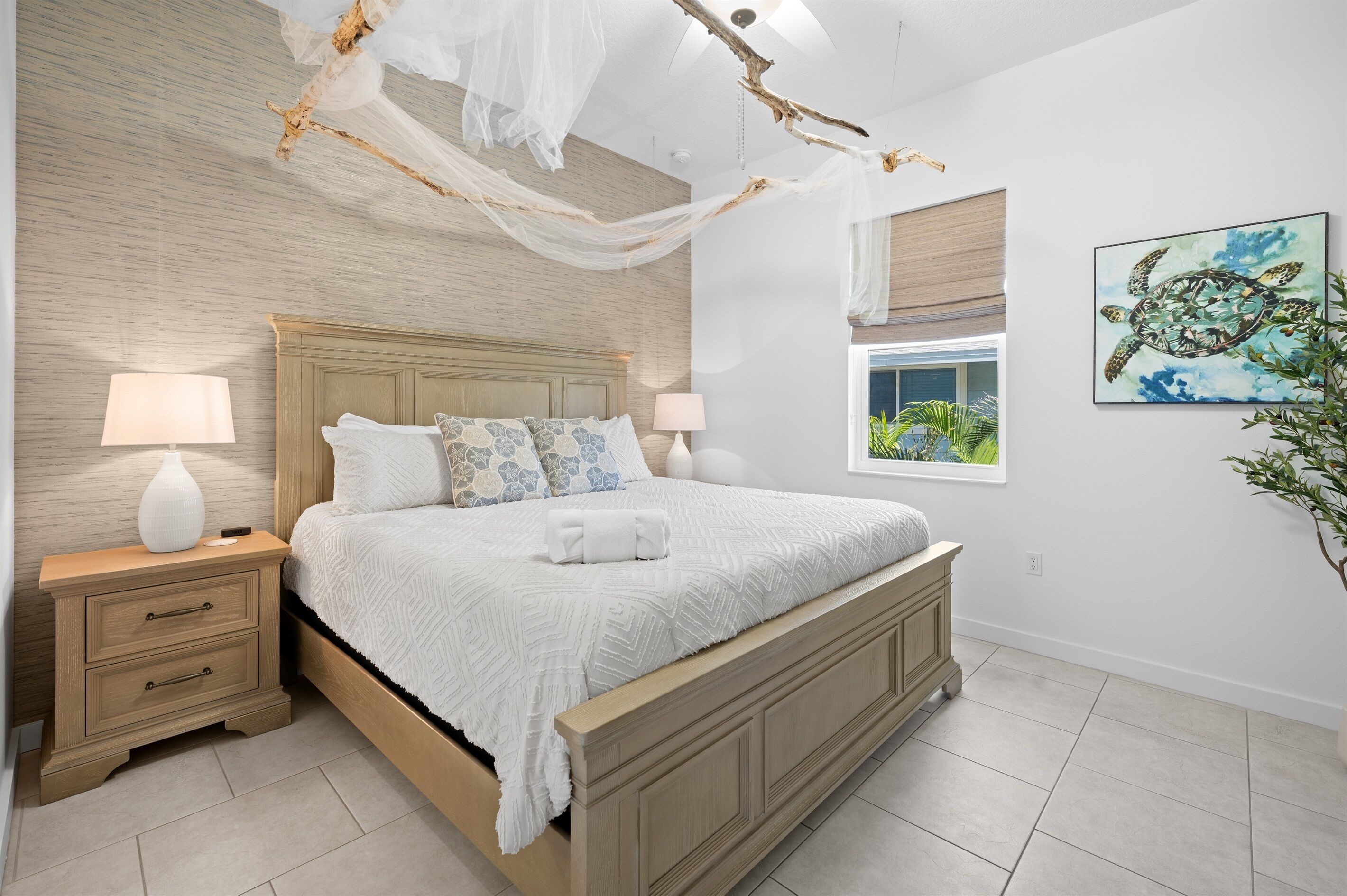 Une chambre à coucher avec un lit en bois, des tables de chevet, un baldaquin et un tableau représentant une tortue.
