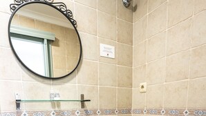 A bathroom with a white sink, toilet, and mirror.