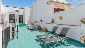A rooftop terrace with two lounge chairs, a table, and potted plants. - Marbella Village  | Appartment with Terrace (Marbella)