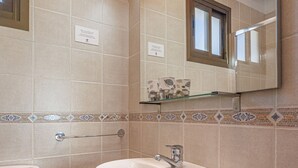 A bathroom with a white sink, a toilet, and a mirror above the sink. - Marbella Village  | Appartment with Terrace (Marbella)