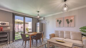 Een moderne woonkamer met een bank, eettafel, stoelen en een vloer met een patroon.