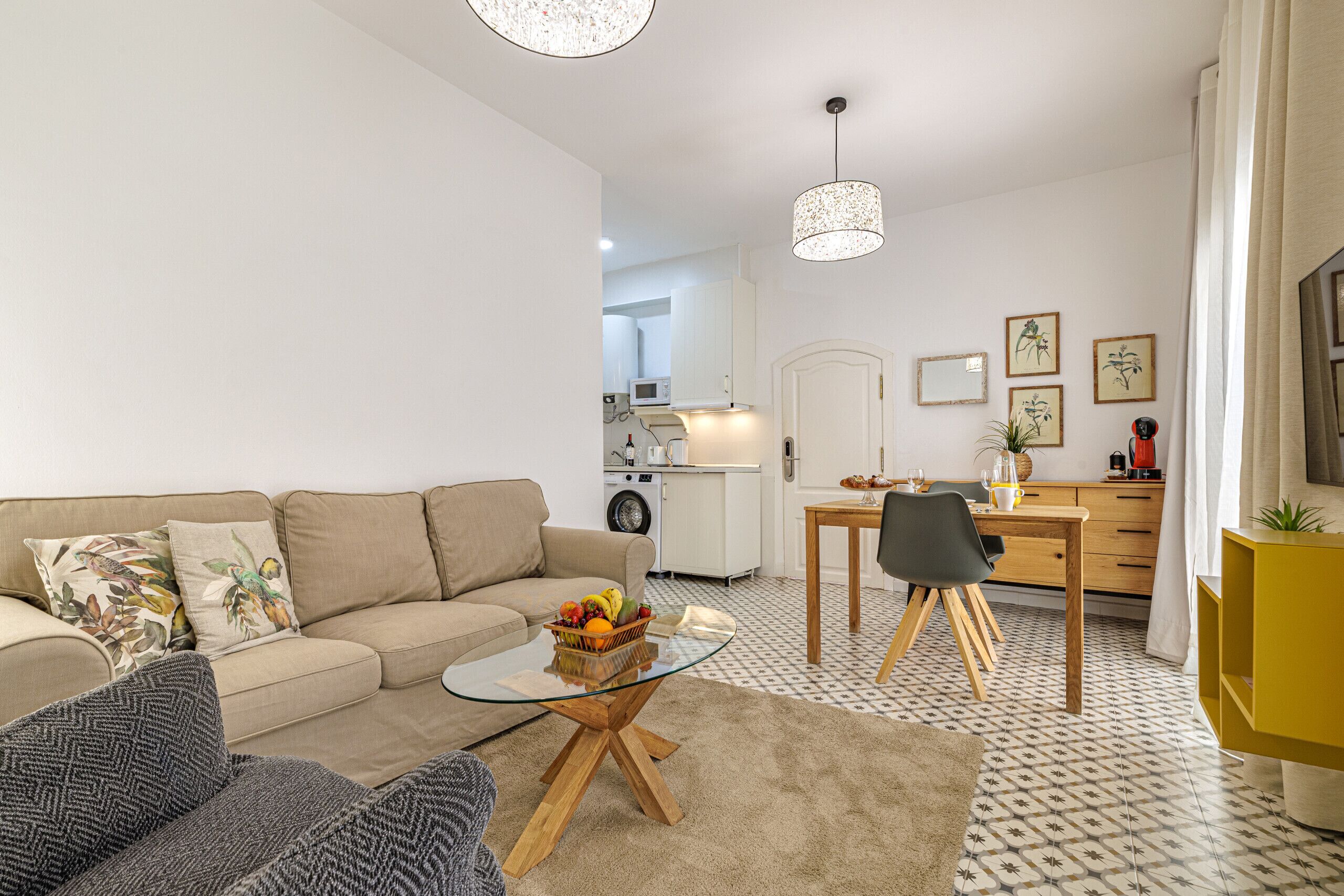 A modern living room with a sofa, coffee table, and dining area.
