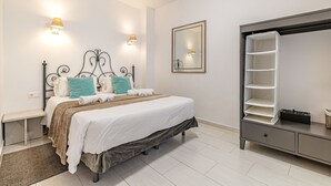 Un dormitorio con cama, lámparas de noche, espejo y armario.