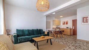 Una sala de estar con sofá, mesa de centro y comedor con sillas y mesa.