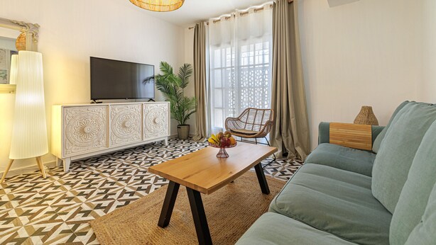 Una sala de estar con un sofá, una mesa de centro, una televisión y un piso con diseño.