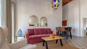 Ein Wohnzimmer mit einer Couch, einem Couchtisch und einem Essbereich mit Stühlen und einem Tisch.