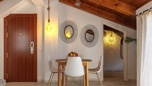 Ein Essbereich mit einem Holztisch, weißen Stühlen und zwei an der Wand befestigten Spiegeln.
