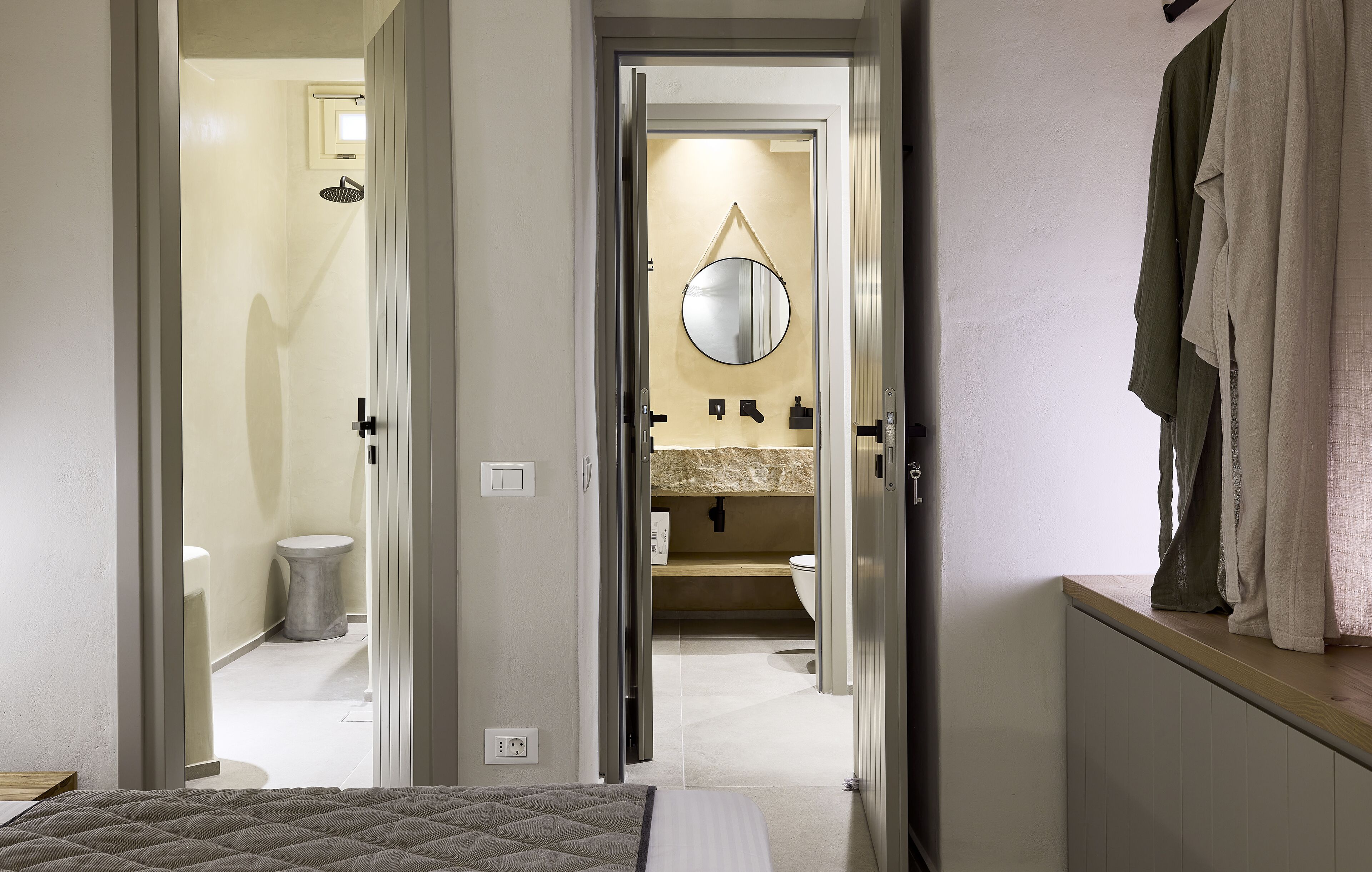 A bedroom with a bed, a bathroom with a toilet, a sink, and a mirror.