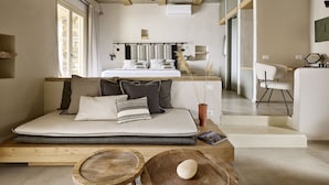 Et moderne soveværelse med en sovesofa, et træbord og et spiseområde med en stol.