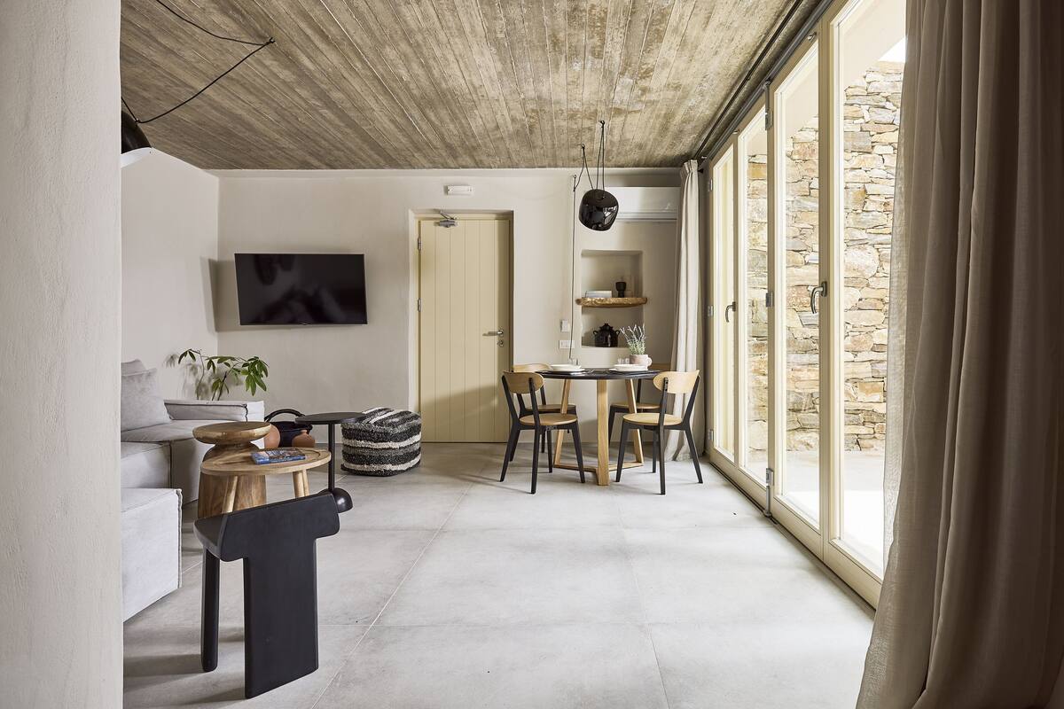Una sala de estar moderna con un sofá, una mesa de centro y un comedor con sillas y una mesa.