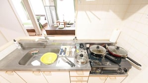 Une cuisine équipée d’un évier, d’une cuisinière et de divers ustensiles.