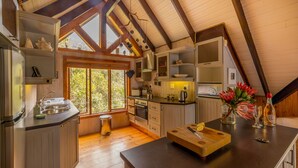 Una cocina moderna con vigas de madera, un ventanal grande y encimera de madera.