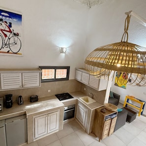 A compact kitchen with a gas stove, a sink, and a small dining area.