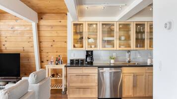 Une cuisine moderne avec des meubles en bois, un lave-vaisselle et un espace dédié à la préparation du café.