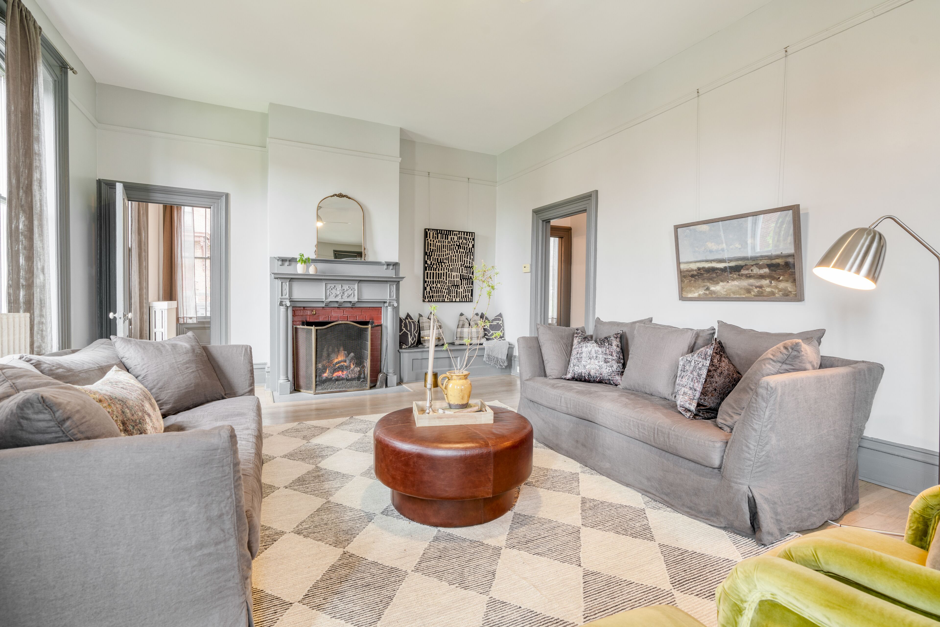 Ein geräumiges Wohnzimmer mit Kamin, zwei Sofas, einem Couchtisch und einer Lampe.