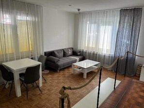 Ein modernes Wohnzimmer mit einer Couch, einem Esstisch und einem Couchtisch.