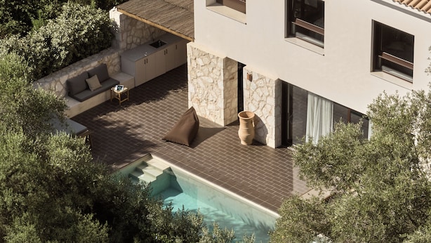 Uma casa moderna com piscina, área de estar externa e paredes de pedra.