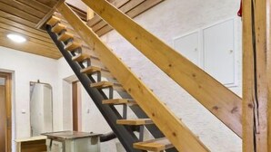 A wooden staircase in a room with tiled flooring and a white wall. - Garden & Pets Escape by Interhome (Tanvald)