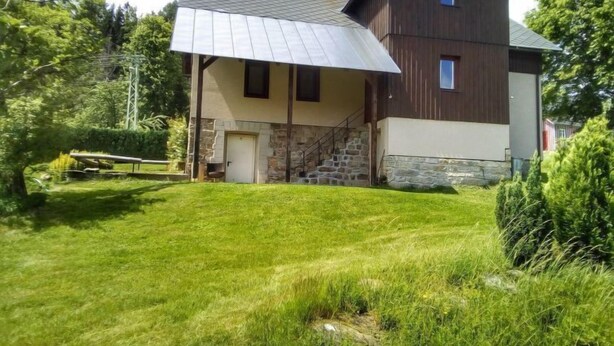 A two-story house with a sloped roof and a covered porch. - Garden & Pets Escape by Interhome (Tanvald)