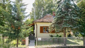Ein Haus mit Ziegeldach, Holztür und einer kleinen Veranda.