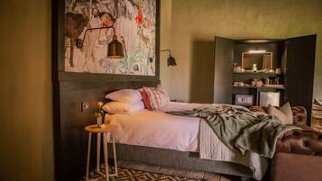 A bedroom with a bed, bedside table, and a large wall painting.