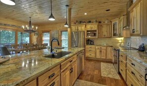 A spacious kitchen with wooden cabinets, granite countertops, and modern appliances.