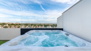 Una vasca idromassaggio su un balcone con vista sulla città.
