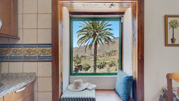 Eine Küche mit Fensterbank, einem Hut und einem Buch.