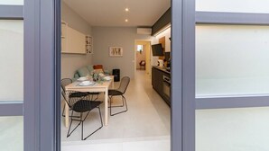 Une cuisine moderne avec un coin repas, comprenant une table avec des chaises, un canapé et un comptoir de cuisine.