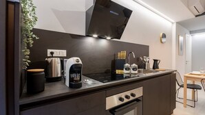 Una cucina moderna con piano cottura integrato, macchina da caffè e lavandino.