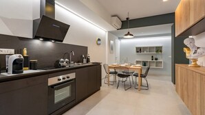 Una cucina moderna con isola centrale, forno integrato e zona pranzo con tavolo e sedie.