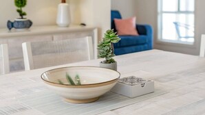 Une table à manger avec un saladier, une plante en pot et une boîte décorative.