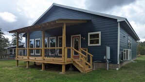 A two-story house with a covered porch and a small deck.