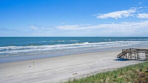 A beach with a wooden structure, likely a lifeguard station, and a clear blue sky. - Oceanfront, Patio, Pool, Tennis, BBQ, Free Parking (St. Augustine)