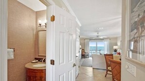 A hotel room with a bathroom featuring a vanity, a large mirror, and a door leading to a balcony. - Oceanfront, Patio, Pool, Tennis, BBQ, Free Parking (St. Augustine)