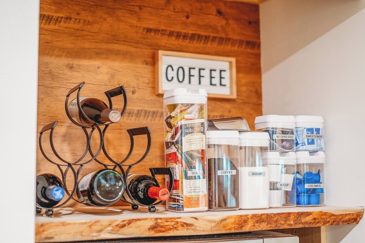 Un coin café équipé de divers accessoires et produits liés au café, et un panneau indiquant le mot « CAFÉ » est accroché au mur.