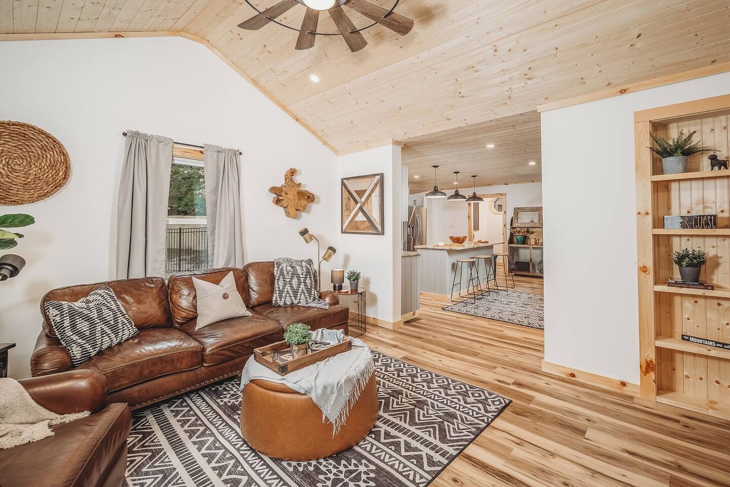 A cozy living room with a leather sofa, patterned rug, and a wooden coffee table.