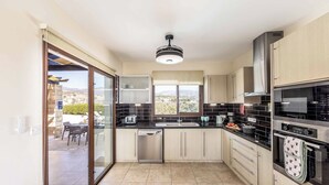 A modern kitchen with a dishwasher, oven, and a view of the outdoors. - Villa Cleco - Three Bedroom Villa, Sleeps 6 (Peyia)