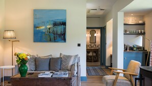 A living room with a sofa, coffee table, and a painting on the wall. - The Lodge at The Yair - Riverside comfort in the Scottish Borders (By Galashiels)