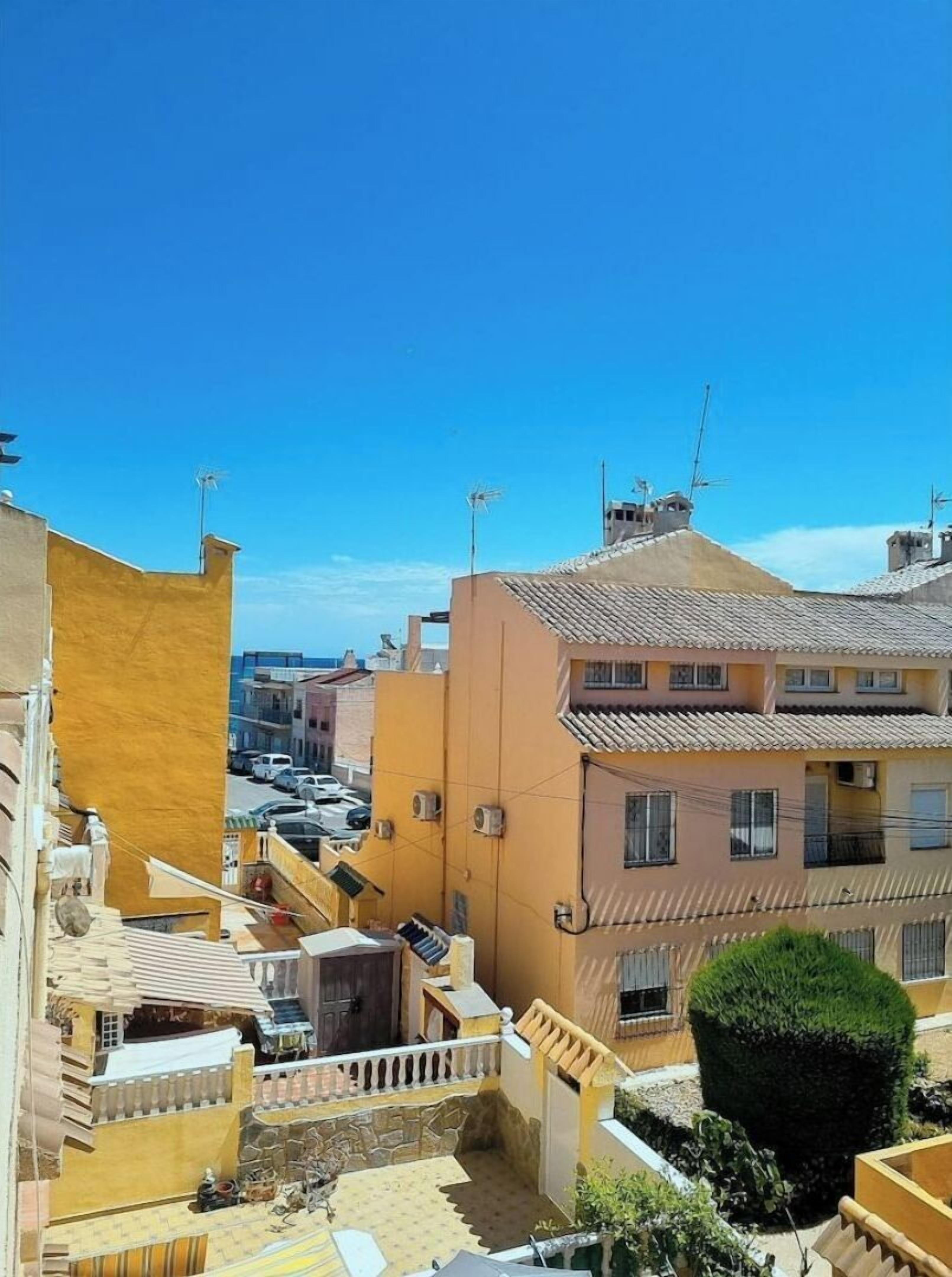 Zona residencial com edifícios que têm telhados de terracota e varandas.