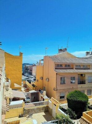 A residential area with buildings featuring terracotta roofs and balconies.