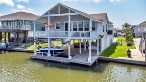 Ein Haus am Wasser mit überdachter Anlegestelle und einem Boot.