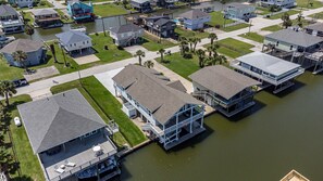 Un quartier résidentiel où les maisons sont situées en bordure d’un plan d’eau, offrant des propriétés avec accès direct à l’eau, dotées de terrasses et de balcons.